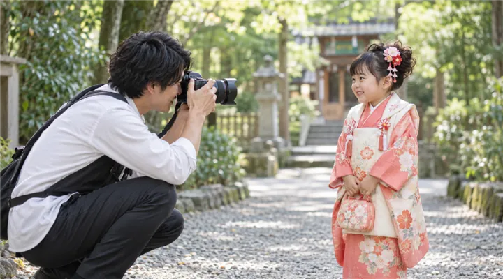 子どもの目線に合わせて撮影するフォトグラファー